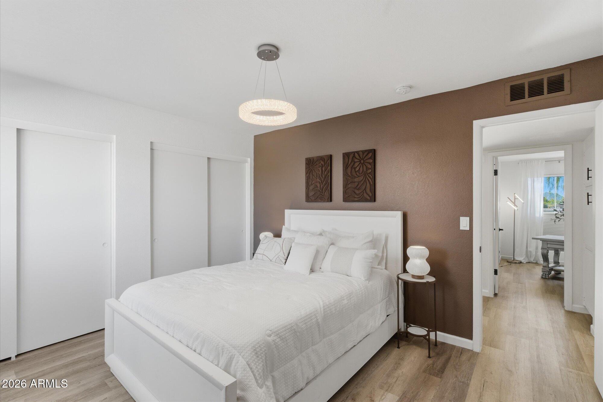 4019 East Charter Oak Road Phoenix, AZ 85032 - Photo 11 of 23 a spacious bedroom with a bed and a wooden floor