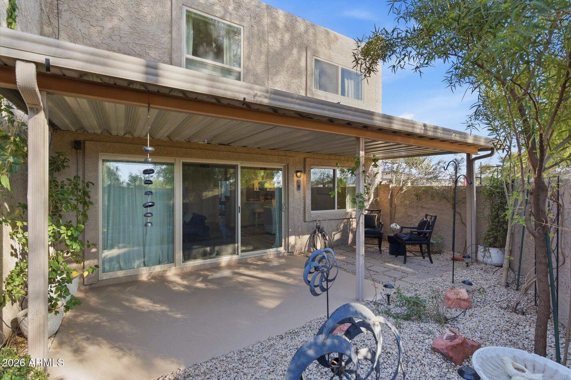 4019 East Charter Oak Road Phoenix, AZ 85032 - Photo 17 of 23 a view of a patio with table and chairs potted plants and floor to ceiling window