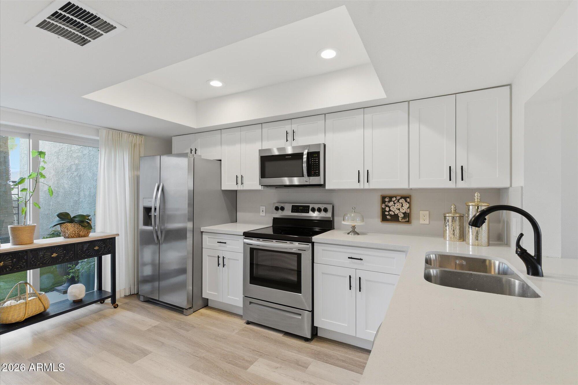 4019 East Charter Oak Road Phoenix, AZ 85032 - Photo 5 of 23 a kitchen with stainless steel appliances granite countertop a refrigerator sink and stove