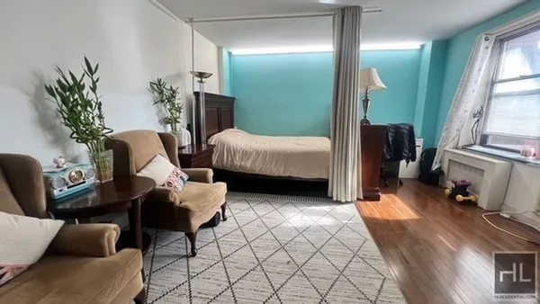 a bedroom with furniture and a large window