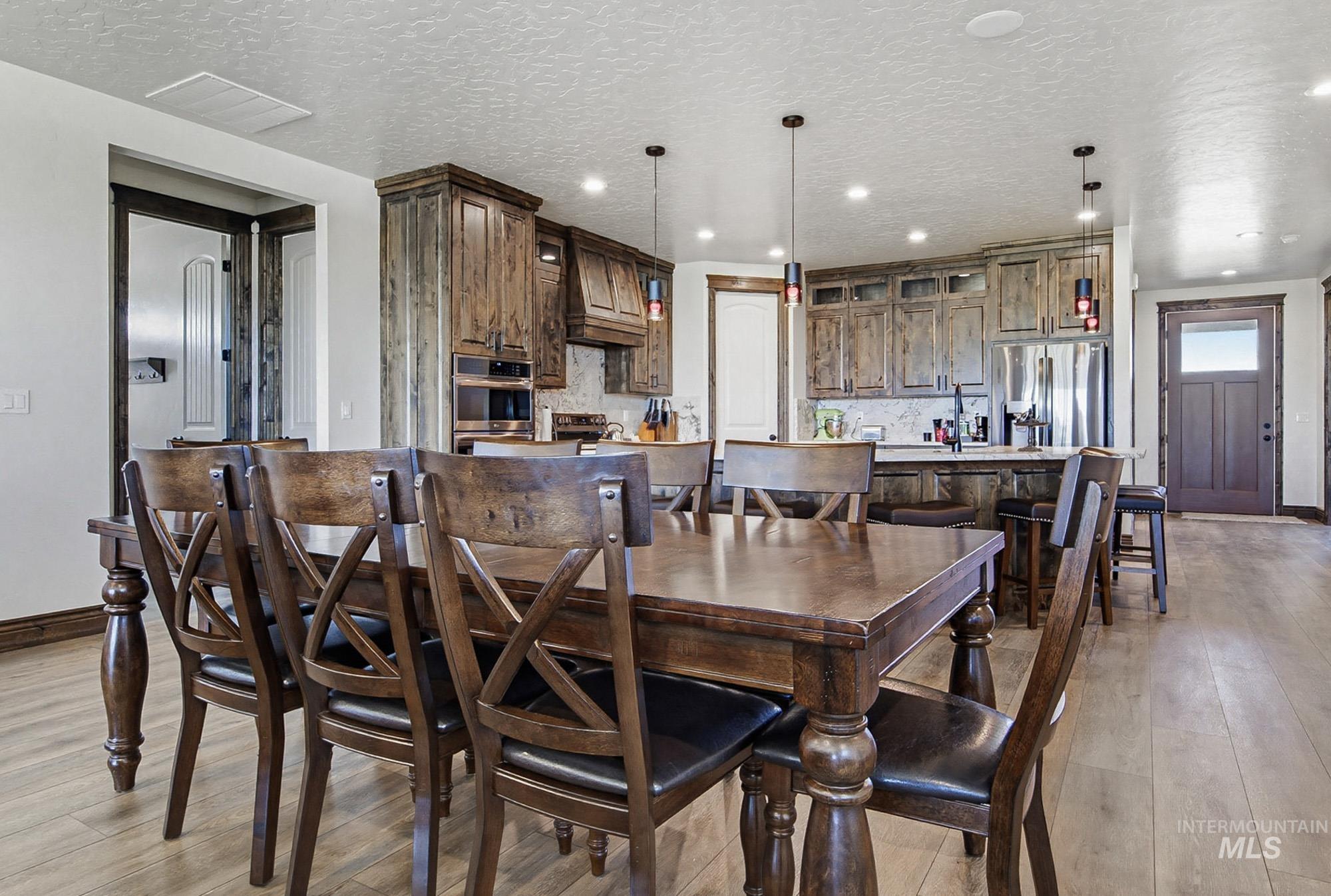 24753 Simplot Boulevard Wilder, ID 83676 - Photo 11 of 47 Dining area with light wood-style flooring, a textured ceiling, and recessed lighting