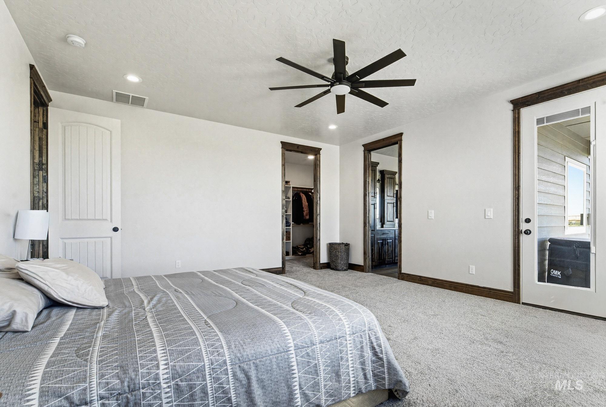 24753 Simplot Boulevard Wilder, ID 83676 - Photo 19 of 47 Carpeted bedroom featuring ensuite bathroom, a ceiling fan, a walk in closet, recessed lighting, and a textured ceiling