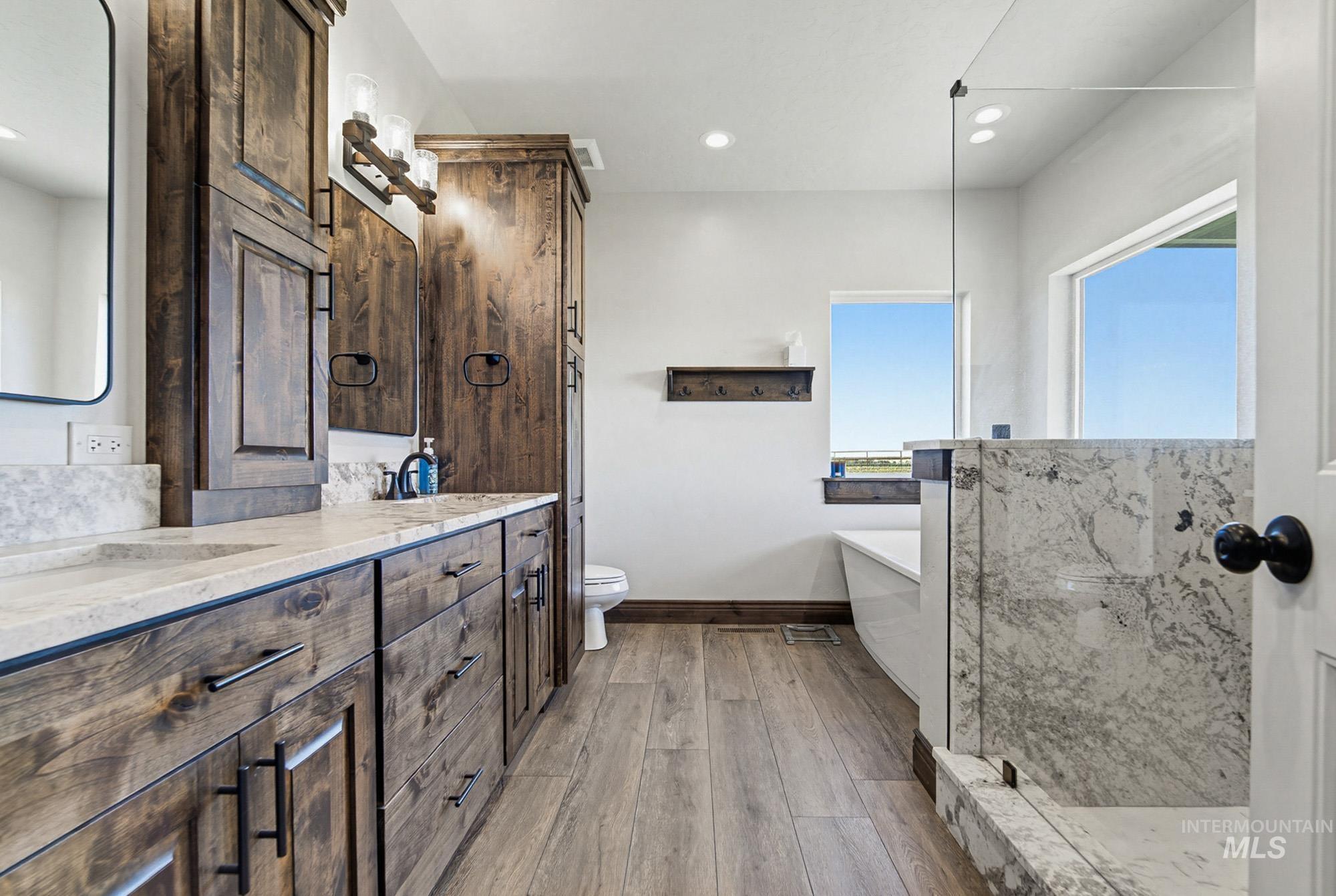24753 Simplot Boulevard Wilder, ID 83676 - Photo 21 of 47 Bathroom with double vanity, light wood-style flooring, a soaking tub, recessed lighting, and a marble finish shower