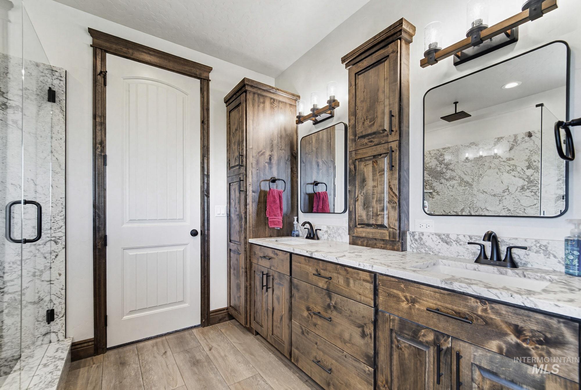 24753 Simplot Boulevard Wilder, ID 83676 - Photo 26 of 47 Full bathroom with double vanity, a marble finish shower, and light wood-style floors
