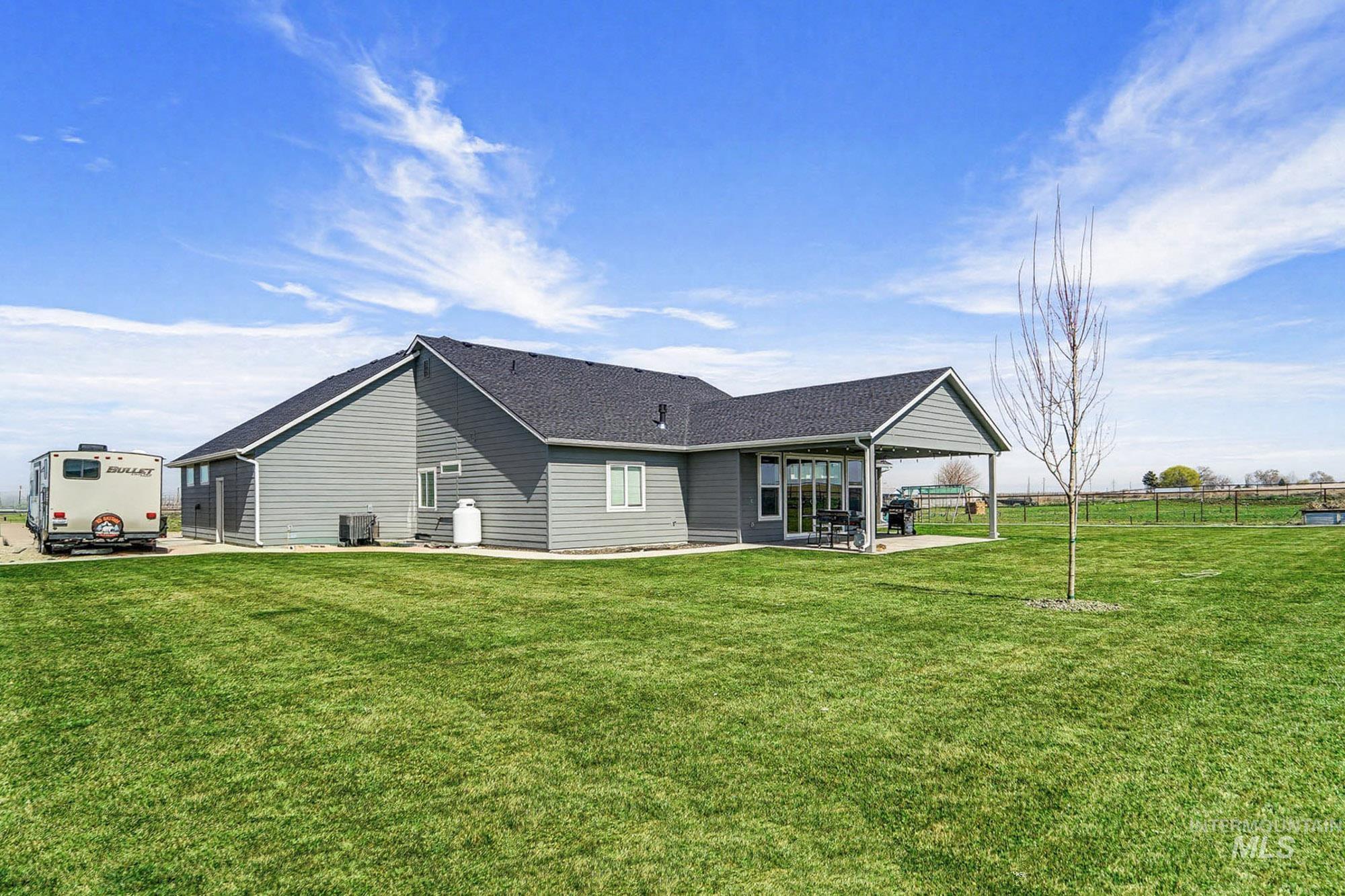 24753 Simplot Boulevard Wilder, ID 83676 - Photo 38 of 47 Back of house with a patio area and roof with shingles