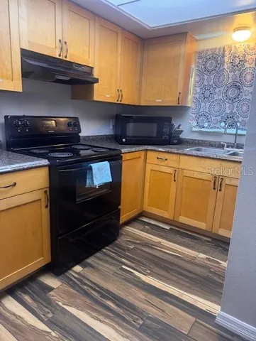 a kitchen with granite countertop cabinets and black appliances