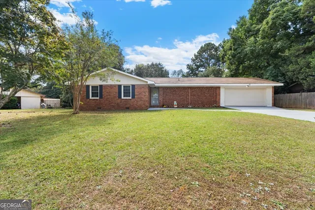 a view of a house with a yard and sitting area
