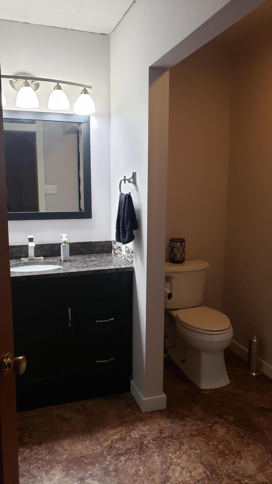 16335 County Line Road Hebron, IN 46341 - Photo 18 of 29 a bathroom with a toilet sink vanity and mirror