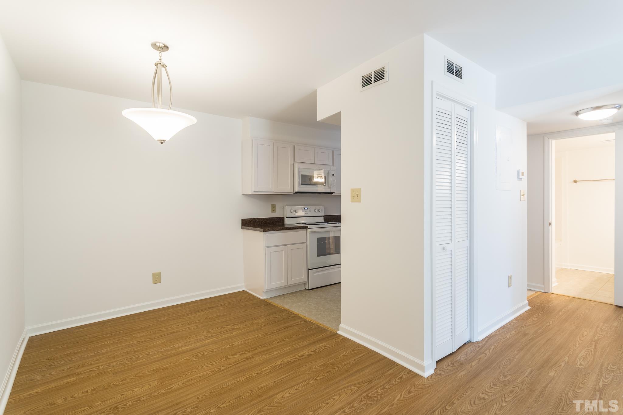 608 Pine Ridge Place, Unit NONE Raleigh, NC 27609 - Photo 5 of 16 a kitchen with a refrigerator and white cabinets