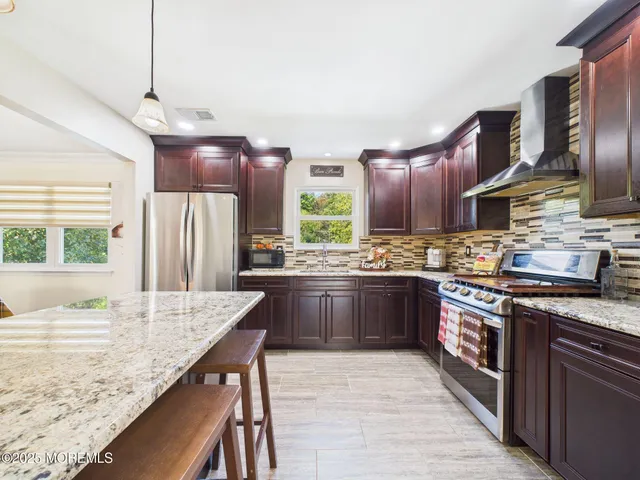 a kitchen with stainless steel appliances granite countertop wooden cabinets a sink and dishwasher