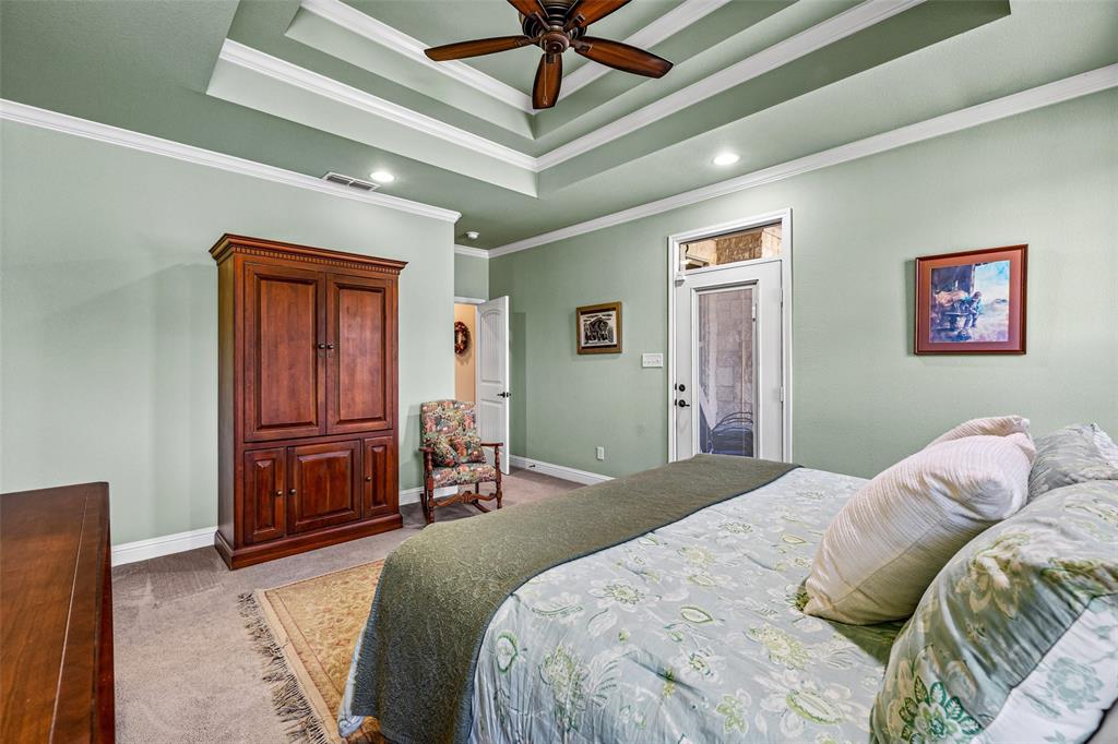 1177 Ronald Road Glen Rose, TX 76043 - Photo 16 of 30 a bedroom with a bed and a chandelier