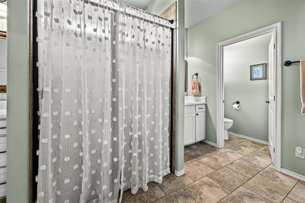 1177 Ronald Road Glen Rose, TX 76043 - Photo 17 of 30 a bathroom with a granite countertop sink a toilet and shower