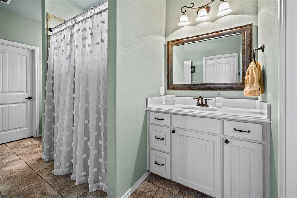 1177 Ronald Road Glen Rose, TX 76043 - Photo 18 of 30 a bathroom with a sink vanity and a mirror