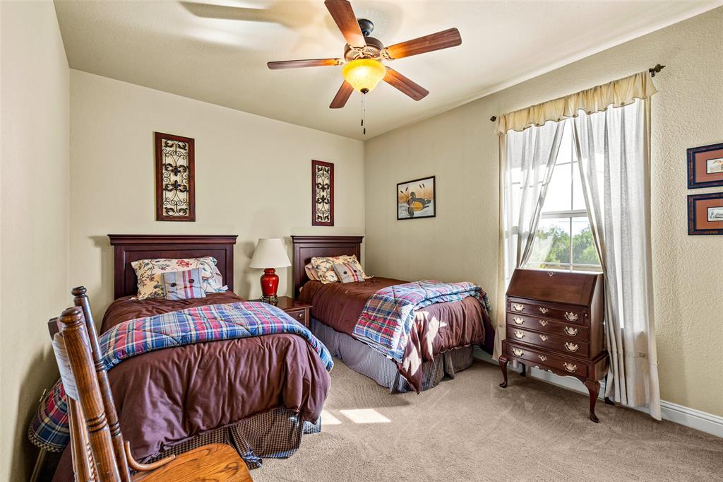 1177 Ronald Road Glen Rose, TX 76043 - Photo 20 of 30 a bedroom with two beds and a chandelier