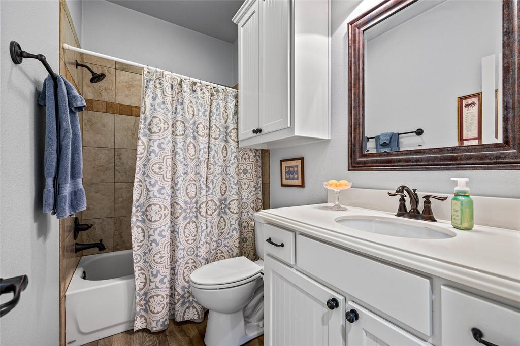 1177 Ronald Road Glen Rose, TX 76043 - Photo 24 of 30 a bathroom with a sink a toilet and a mirror