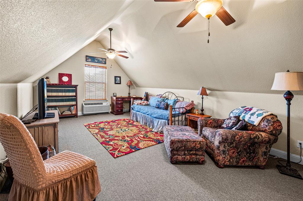 1177 Ronald Road Glen Rose, TX 76043 - Photo 25 of 30 a bedroom with furniture and a chandelier