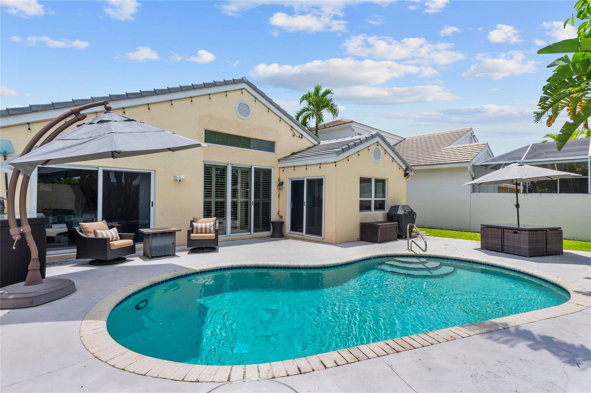 7904 Travelers Tree Drive Boca Raton, FL 33433 - Photo 1 of 35 a view of a house with swimming pool and sitting area