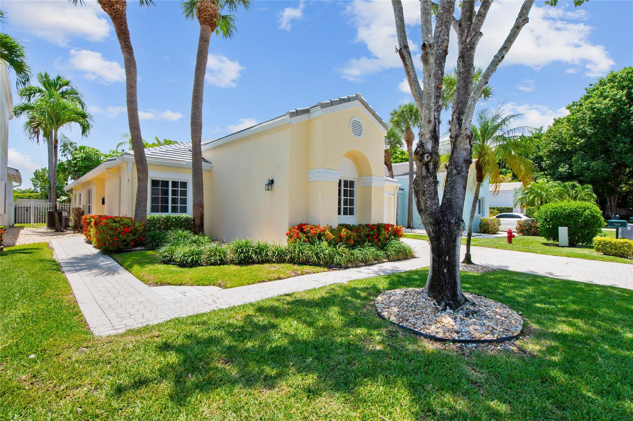 7904 Travelers Tree Drive Boca Raton, FL 33433 - Photo 2 of 35 a front view of a house with garden and trees