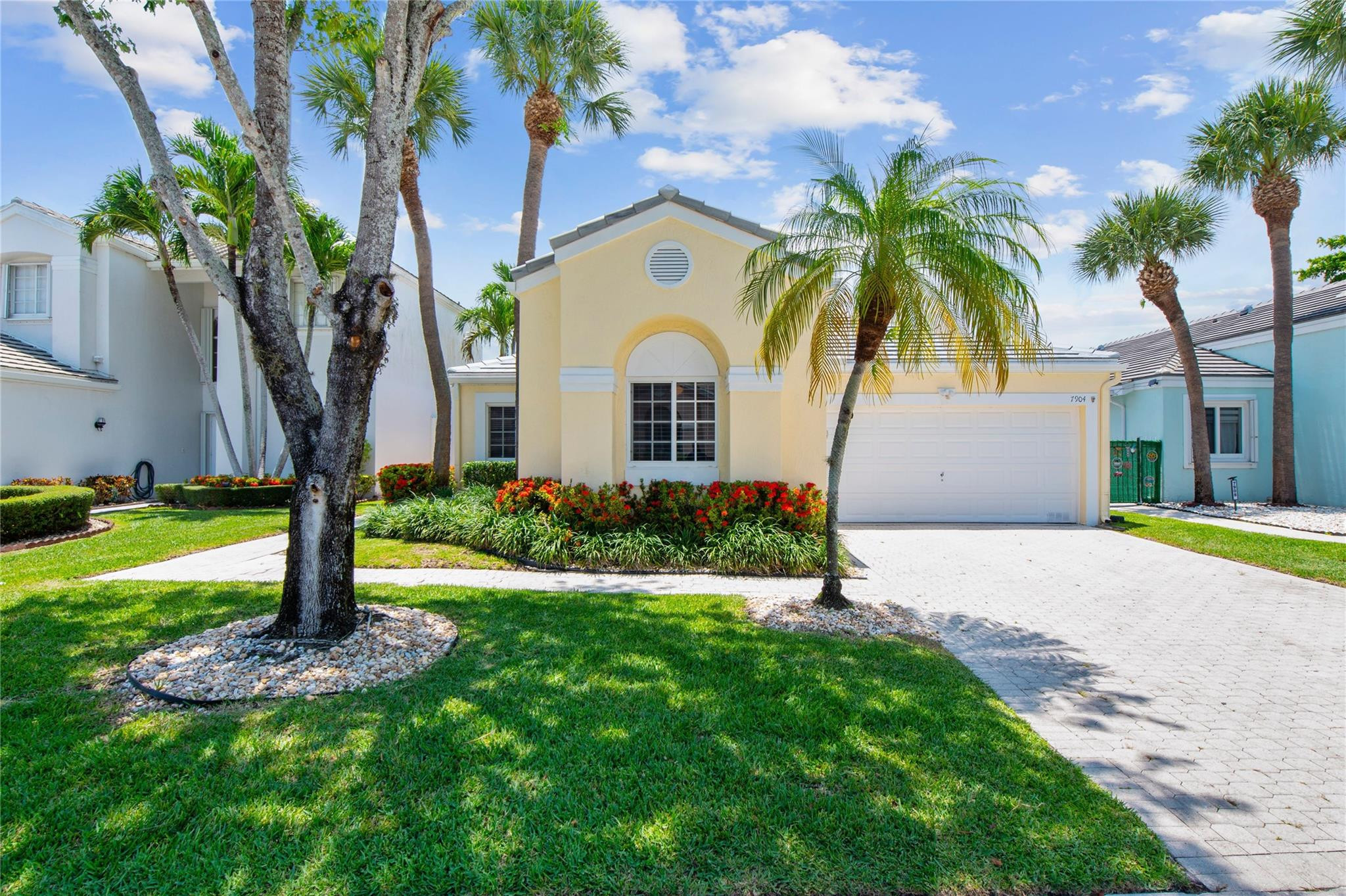 7904 Travelers Tree Drive Boca Raton, FL 33433 - Photo 3 of 35 a front view of a house with garden and trees