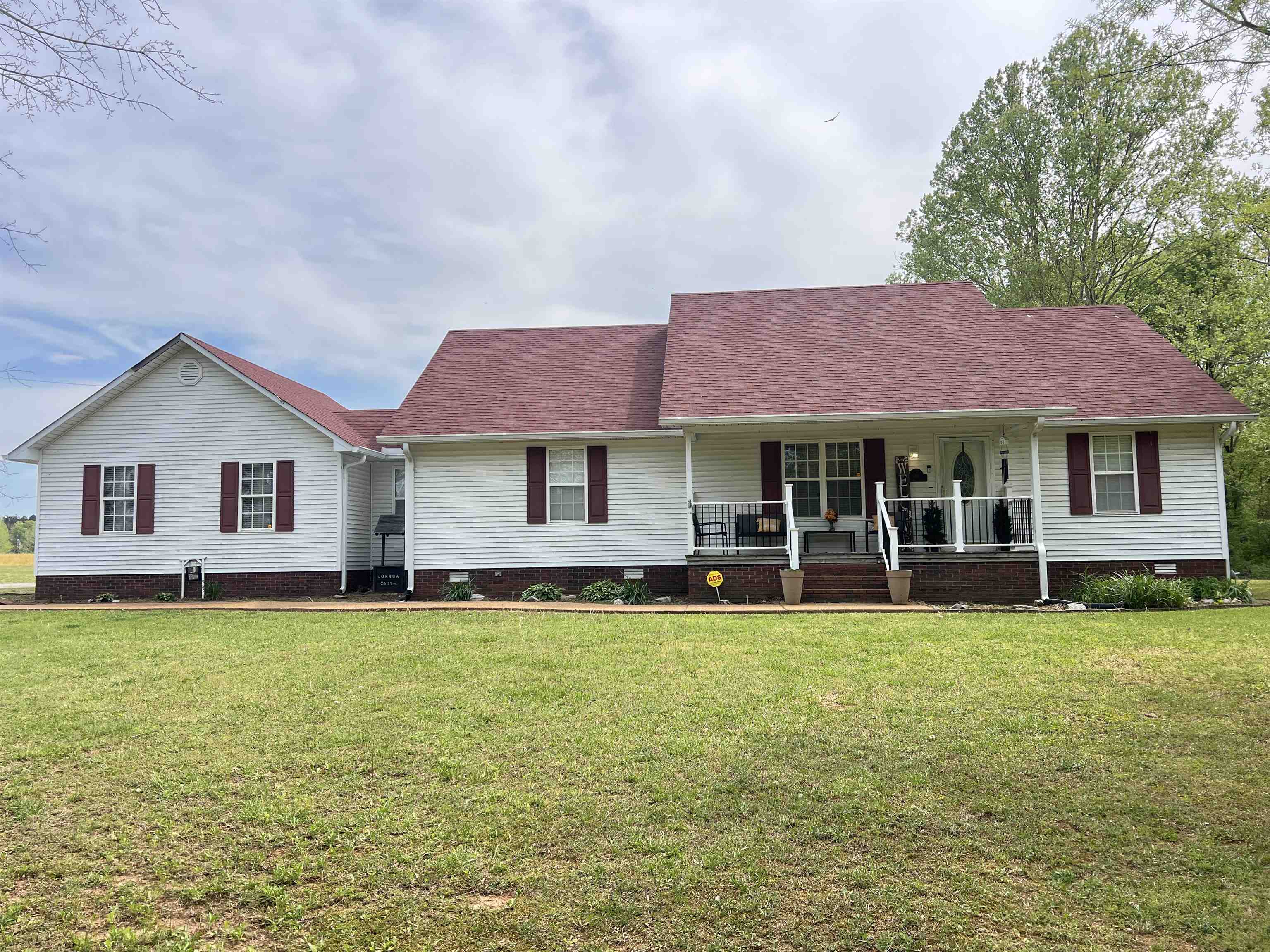 a front view of a house with a garden and trees