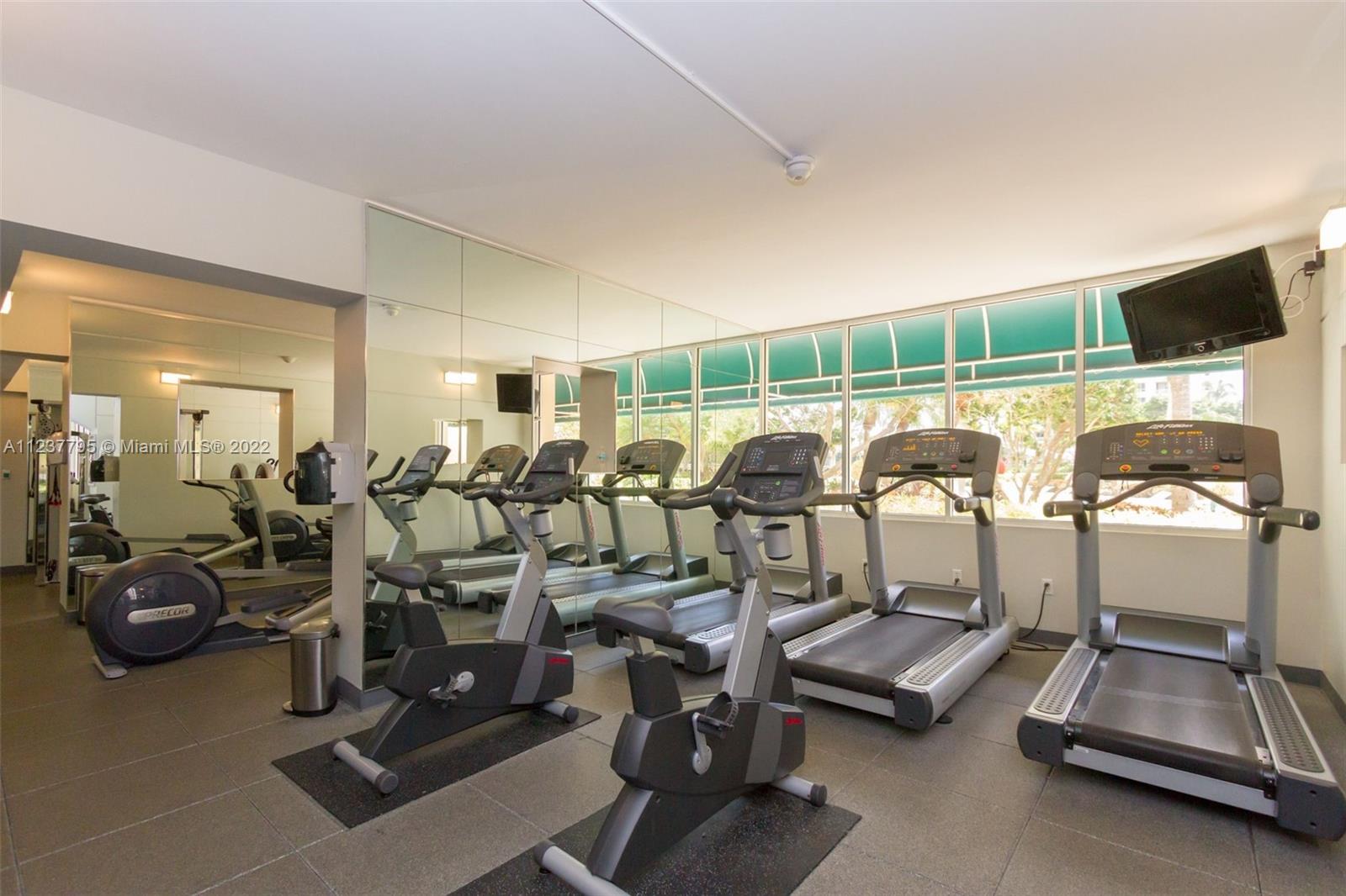 888 Brickell Key Drive, Unit PH2802 Miami, FL 33131 - Photo 43 of 47 a room with gym equipment and large mirror