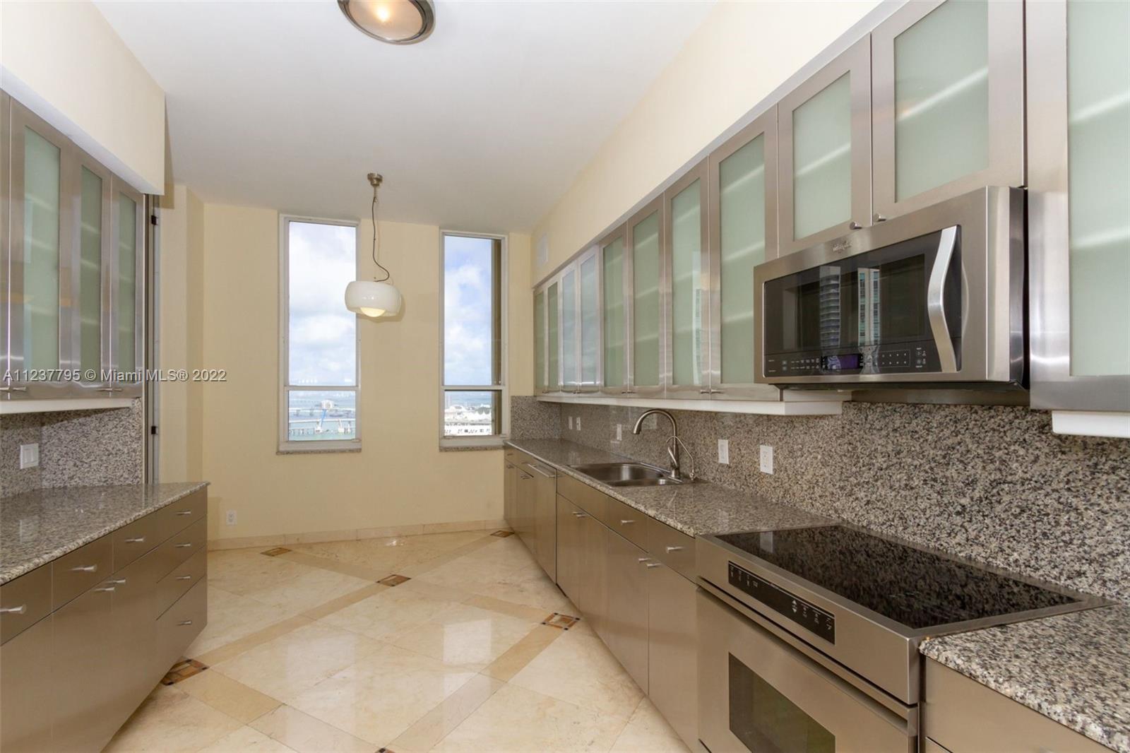 888 Brickell Key Drive, Unit PH2802 Miami, FL 33131 - Photo 7 of 47 a kitchen with granite countertop a sink and a stove
