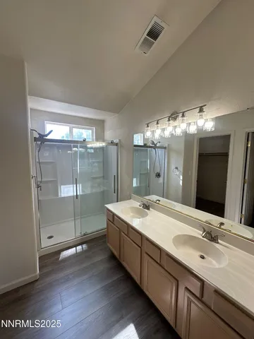 a spacious bathroom with a double vanity sink mirror and shower