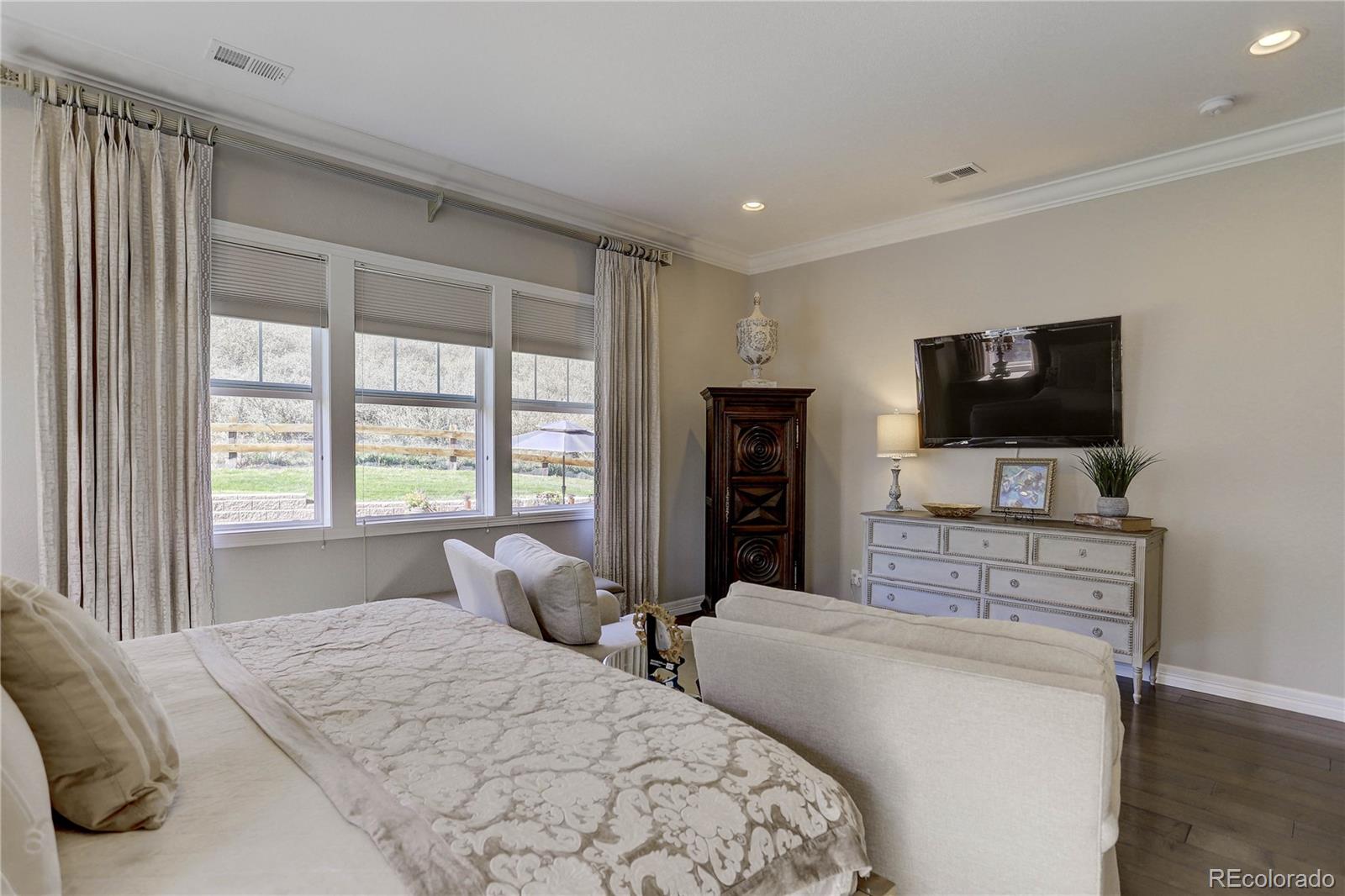 4907 Hogback Ridge Road Morrison, CO 80465 - Photo 20 of 47 a bedroom with a bed and a flat screen tv on dresser