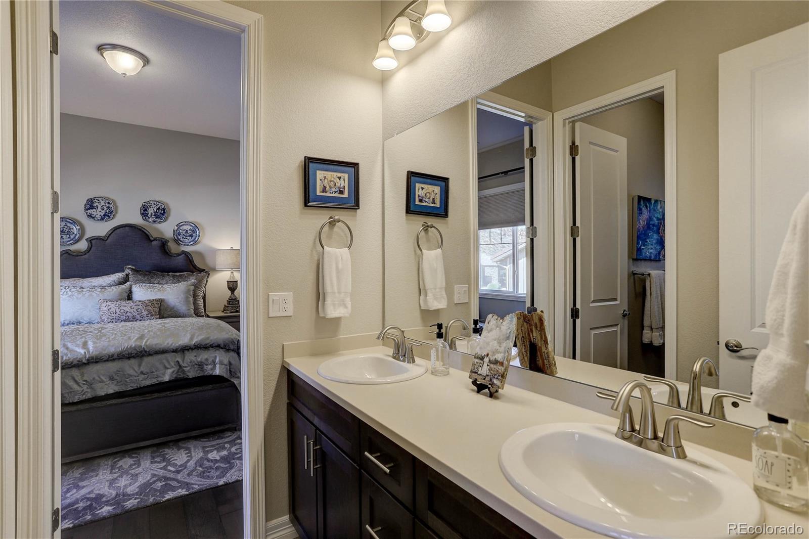 4907 Hogback Ridge Road Morrison, CO 80465 - Photo 26 of 47 a en suite bathroom with a double vanity sink and a mirror