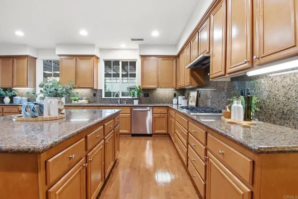 a kitchen with kitchen island granite countertop a sink a counter space appliances and cabinets
