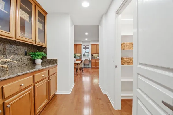 a hallway with wooden floors and cabinet