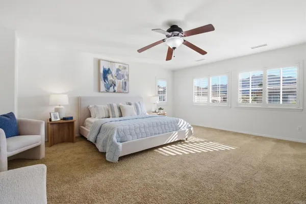a spacious bedroom with a bed couch and window
