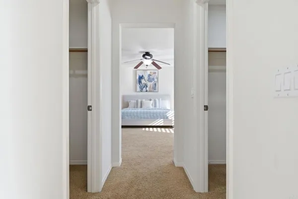 a view of a hallway view with wooden floor and a bathroom