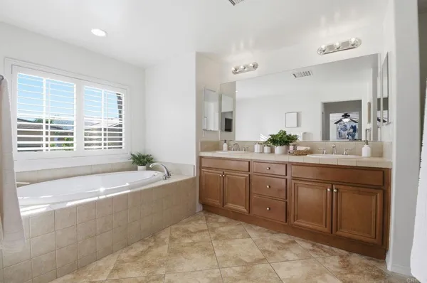 a spacious bathroom with a granite countertop tub sink and mirror