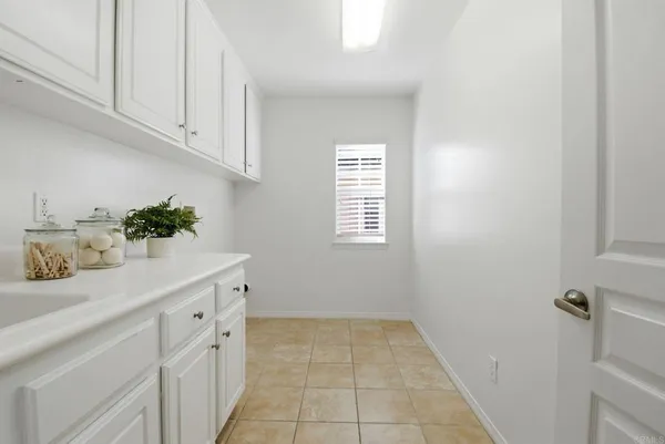 a bathroom with a sink a window and cabinets