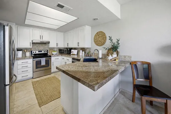 a kitchen with stainless steel appliances granite countertop a sink and stove top oven