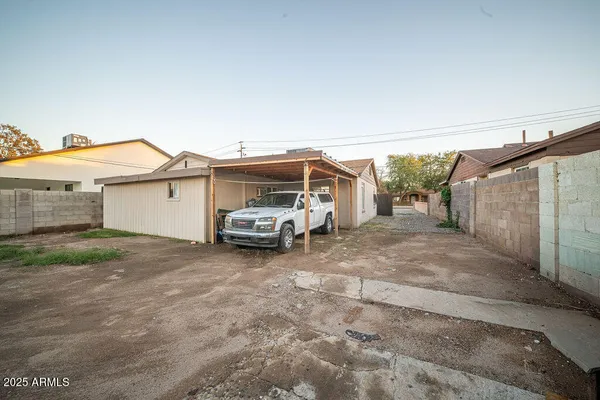 a view of a house with a backyard and parking space