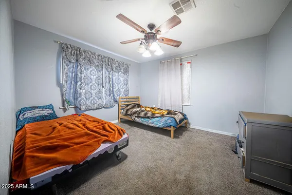 a bedroom with two beds and ceiling fan