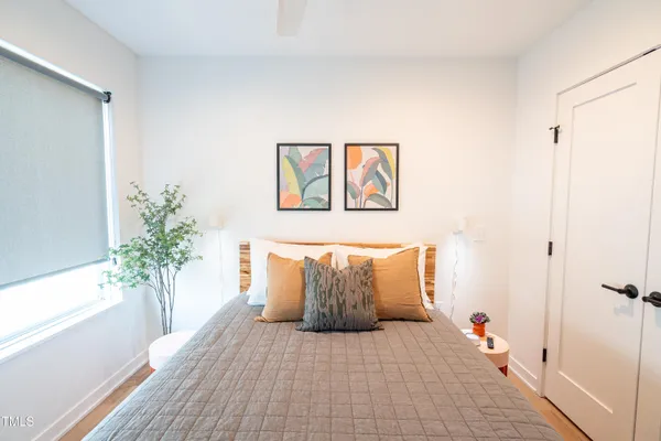 a spacious bedroom with a large bed and a potted plant