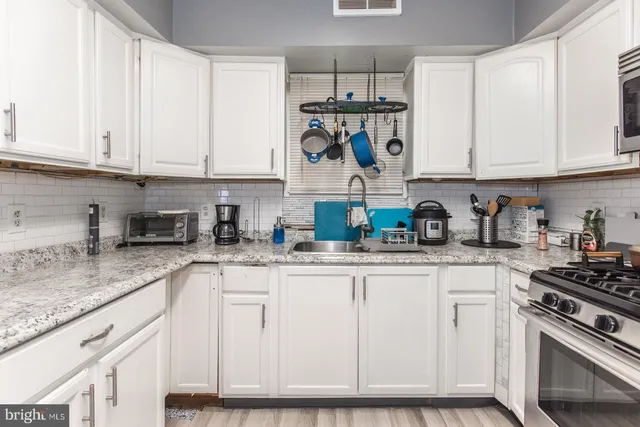 a kitchen with white cabinets and appliances