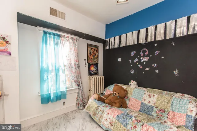 a bed sitting in a bedroom next to a window