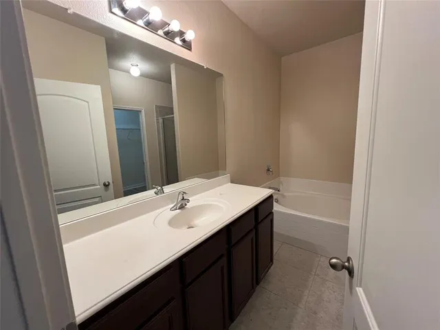 a bathroom with a tub sink and mirror