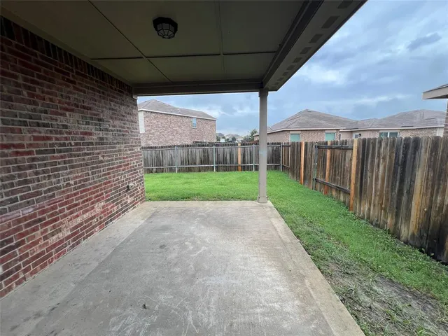 a view of a backyard with table and chairs under an umbrella
