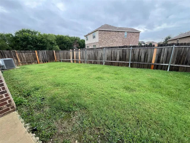 a view of a backyard with wooden fence