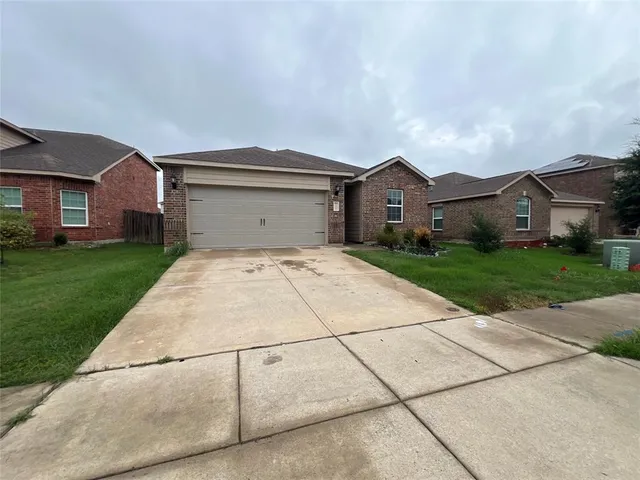 a view of a house with a yard and large tree