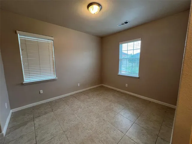 an empty room with windows and closet