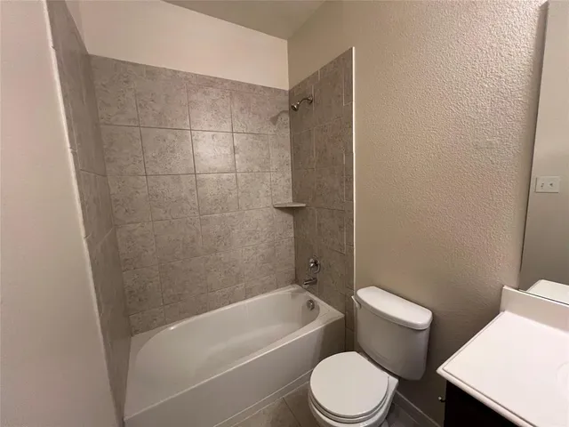 a white toilet and tub sitting next to a bathroom sink