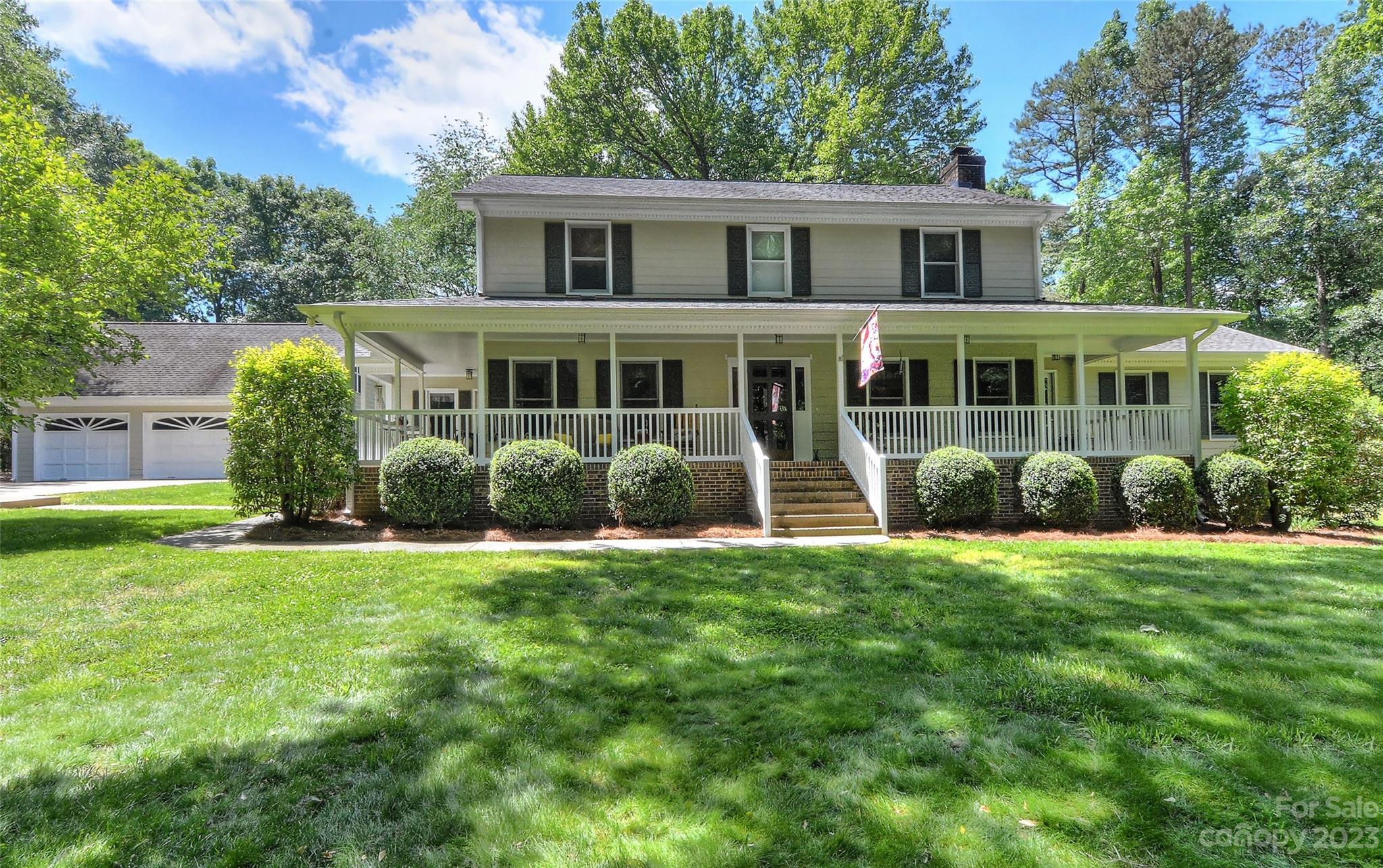 a front view of a house with a yard and trees