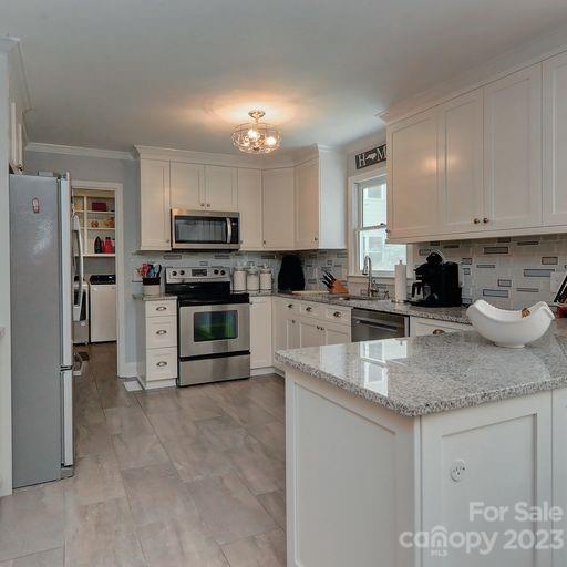 900 Woodland Forest Road Marvin, NC 28173 - Photo 8 of 36 a kitchen with stainless steel appliances granite countertop a stove top oven a sink a refrigerator and white cabinets