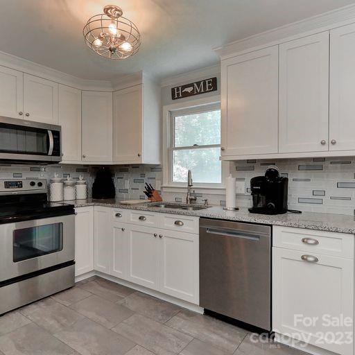 900 Woodland Forest Road Marvin, NC 28173 - Photo 9 of 36 a kitchen with white cabinets appliances and a sink
